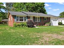 Charming single-story brick home featuring green shutters, a well-kept lawn, and an attached single-car garage at 5321 Trudy St, North Charleston, SC 29418
