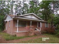 Charming brick home featuring a covered front porch, perfect for enjoying the outdoors at 604 King St, Walterboro, SC 29488