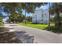 Charming two-story home with light-blue siding, a manicured lawn and a traditional staircase at 912 Cheehaw St, Edisto Island, SC 29438