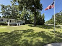 Charming home with a spacious lawn and an American flag waving in the breeze at 1210 Azalea Dr, Summerville, SC 29483