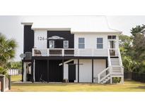 Charming elevated home with a crisp black and white exterior and a relaxing outdoor deck at 126-C Jungle Rd, Edisto Beach, SC 29438