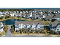 Gorgeous aerial view of a neighborhood with townhomes, a pond, and lush greenery, offering serene waterfront living at 1614 Prince Edward St, Mount Pleasant, SC 29466