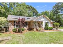 Charming single-story brick home with solar panels, landscaped yard, and welcoming front porch at 1705 Sulgrave Rd, Charleston, SC 29414
