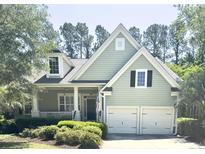 Charming two-story home featuring an attached two-car garage, landscaped yard, and inviting front porch at 1736 James Basford Pl, Mount Pleasant, SC 29466