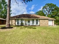 Charming single-story home featuring a brick facade, white trim, and a well-maintained lawn at 207 Longstreet St, Summerville, SC 29486