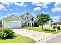Charming two-story home featuring a manicured lawn and attached two-car garage at 303 Seneca River Dr, Summerville, SC 29485