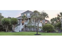 Charming coastal home with elevated stairs, mature landscaping, and a welcoming front porch at 314 Commonwealth Rd, Mount Pleasant, SC 29466