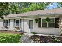 Charming brick home featuring a welcoming front door, manicured lawn and flower beds at 323 Millcreek Dr, Charleston, SC 29407
