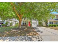 Charming home with white siding, a red door, and a well-maintained front yard, shaded by a mature tree at 3661 Locklear Ln, Mount Pleasant, SC 29466