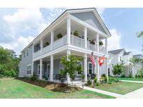 Charming two-story home featuring a spacious porch, landscaped yard, and inviting curb appeal at 397 Woodgate Way, Summerville, SC 29485