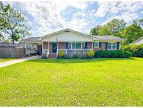 Charming single-story brick home featuring a well-maintained lawn and inviting front porch at 404 Rose Ln, Summerville, SC 29485