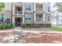 Three-story condo building showcasing balconies and well-maintained landscaping at 700 Daniel Ellis Dr # 4107, Charleston, SC 29412