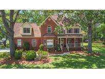Charming two-story brick home with well-manicured lawn, mature trees and inviting front porch at 8661 Laurel Grove Ln, North Charleston, SC 29420