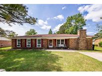 Charming brick home features a well-manicured lawn, red shutters, and inviting front porch at 104 Clover St, Summerville, SC 29483