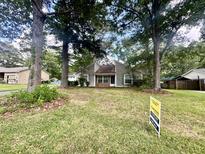 Charming single-story home with mature trees and a lush green lawn and a 'for sale' sign in the yard at 120 Wanda Dr, Summerville, SC 29485