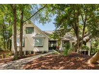 Charming two-story home with a beautifully landscaped front yard and mature trees for added privacy at 15 Edgewater Aly, Isle of Palms, SC 29451