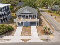 Charming coastal home featuring a spacious wrap-around porch and convenient drive-under parking at 1701 A Palmetto Blvd, Edisto Island, SC 29438