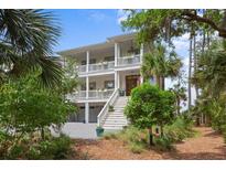 Charming two-story home with double balconies, landscaped yard, and stairway leading to the entrance at 1801 Landfall Way, Seabrook Island, SC 29455
