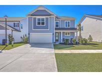 Charming two-story home with a manicured lawn, inviting front porch, and a spacious driveway at 215 Shortmarsh St, Summerville, SC 29486