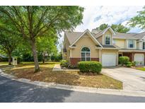 Charming tan townhouse with brick accents, manicured landscaping, and an attached single-car garage at 247 Darcy Ave, Goose Creek, SC 29445