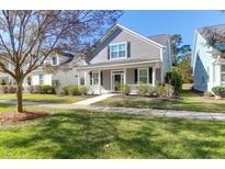 Charming gray two-story home with a inviting front porch and well-maintained lawn on a bright day at 2909 Swamp Sparrow Cir, Johns Island, SC 29455