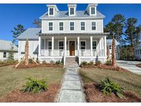 Charming two-story home showcasing a welcoming front porch and manicured lawn on a sunny day at 3894 Summerton St, Mount Pleasant, SC 29466
