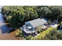Stunning elevated coastal home with a deck, manicured lawn, and lush surrounding landscape at 4940 Lambs Road Rd, North Charleston, SC 29418