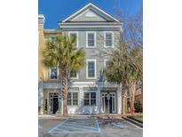 Three-story townhome with a blue-gray facade, white trim, and palm trees in the front at 656 Coleman Blvd # 405, Mount Pleasant, SC 29464