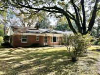 Charming brick home with a well-manicured lawn and mature trees creating a peaceful setting at 922 Dill Ave, Charleston, SC 29412