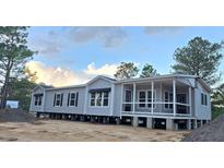 Charming manufactured home featuring a welcoming front porch with white railing at 966 Tiger Loop, Saint Stephen, SC 29479