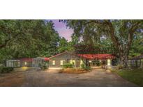 Charming single-story home featuring a red roof, covered parking, and a well-manicured front yard surrounded by lush trees at 1010 Black Oak Rd, Bonneau, SC 29431