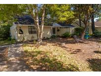 Quaint single-story home features a cozy front yard with mature trees providing ample shade at 1116 Daffodil Ln, Mount Pleasant, SC 29464