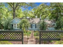Charming single-story home with a brick pathway, lush landscaping, and a decorative black metal fence at 1316 Wichman St, Walterboro, SC 29488