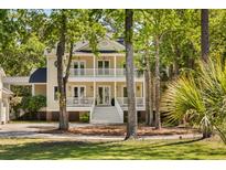 Charming two-story home with a welcoming double front porch and picturesque landscaping at 1505 Rivertowne Country Club Dr, Mount Pleasant, SC 29466