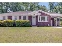 Charming brick home with a well-manicured lawn and mature landscaping at 1821 Wasp St, North Charleston, SC 29405