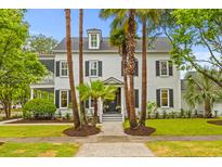 Charming two-story white home with black shutters, well-maintained landscaping, and mature palm trees at 2 Pagett St, Daniel Island, SC 29492