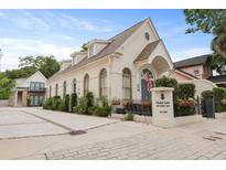 Elegant building featuring a white facade, arched windows, and manicured landscaping at 221 Ashley Ave # Abc, Charleston, SC 29403