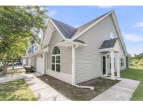 Light gray townhouse featuring a charming architectural design with a covered entrance and an arched window detail at 281 Jackson St, Goose Creek, SC 29445