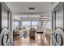 Bright, open-concept living room with hardwood floors, staircase, and water views at 330 Concord St # 18F, Charleston, SC 29401