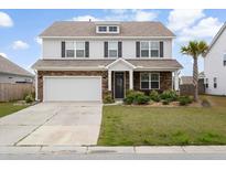 Charming two-story home with a stone facade, a well-maintained lawn, and a two-car garage at 413 Ribiero Dr, Summerville, SC 29486