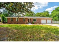 Charming brick home with a well-manicured lawn and attached two-car garage at 5823 Lakeview Dr, Hanahan, SC 29410