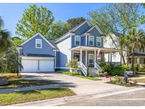 Charming two-story home with a manicured lawn, a two-car garage, and a welcoming front porch at 700 Preservation Pl, Mount Pleasant, SC 29464