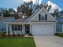 Charming single-story home with a well-manicured lawn, attached garage, and inviting entryway at 753 Maynard Ln, Summerville, SC 29486