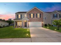 Charming two-story home with a brick facade, well-manicured lawn, and inviting front porch at 110 Levis Song Ct, Goose Creek, SC 29445