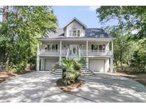 Charming home featuring a double porch, garage and elegant staircase leading to the front door at 1325 Moss Path, Mount Pleasant, SC 29464