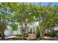 Charming two-story home with brick steps, a gray facade, and mature trees at 15 Rutledge Ave, Charleston, SC 29401