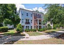 View of townhomes with manicured landscaping, blue and brown accents, and a welcoming entryway at 1589 Bluewater Way, Charleston, SC 29414