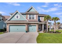 Charming brick home with a two-car garage, palm trees, and well-manicured lawn at 185 Whaler Ave, Summerville, SC 29486