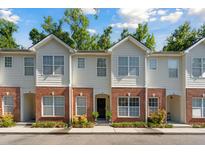Charming townhouse featuring a brick facade, well-manicured landscaping, and multiple windows at 241 Howle Ave # F, Charleston, SC 29412