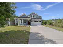 Charming blue two-story home with a well-manicured lawn and a two-car garage at 267 Palmetto Walk Dr, Summerville, SC 29486